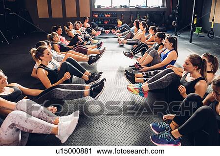 Large group of women training in gym, sitting in rows on floor with legs raised View Large Photo Image Stock Image - Large group of women training in gym, sitting in rows on floor with legs raised. Fotosearch