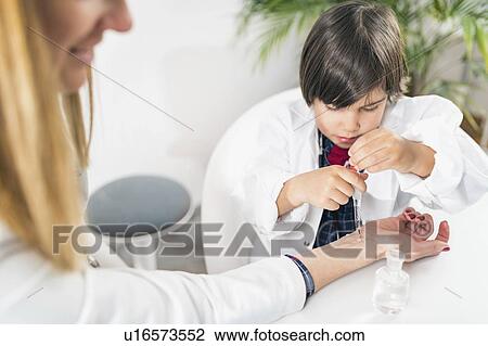 Stock Image - Little boy playing at being a doctor. Fotosearch
