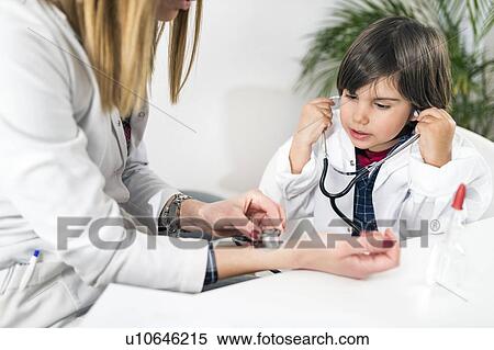 Stock Photography - Little boy playing at being a doctor. Fotosearch