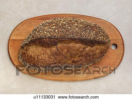 Loaf of bread on cutting board View Large Photo Image Stock Image - Loaf of bread on cutting board. Fotosearch