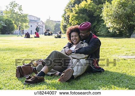 Stock Photo - Loving couple hugging on grass, Milan, Italy. Fotosearch
