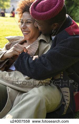 Stock Photo - Loving couple hugging on grass, Milan, Italy. Fotosearch