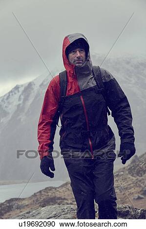 Male hiker looking up while hiking in snow capped mountains with storm clouds, Llanberis, Gwynedd, Wales View Large Photo Image Stock Image - Male hiker looking up while hiking in snow capped mountains with storm clouds, Llanberis, Gwynedd, Wales. Fotosearch