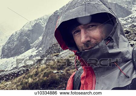 Male hiker with hood up in sleeting snow capped mountain landscape, close up portrait, Llanberis, Gwynedd, Wales View Large Photo Image Stock Photograph - Male hiker with hood up in sleeting snow capped mountain landscape, close up portrait, Llanberis, Gwynedd, Wales. Fotosearch