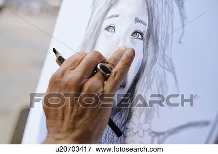 Stock Photo - Male street artist drawing and smudging canvas, close up of hand, Madrid, Spain. Fotosearch