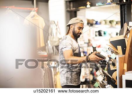 Man choosing skateboard in shop View Large Photo Image Stock Image - Man choosing skateboard in shop. Fotosearch