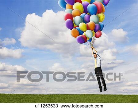 Man holding helium balloons View Large Photo Image Stock Image - Man holding helium balloons. Fotosearch