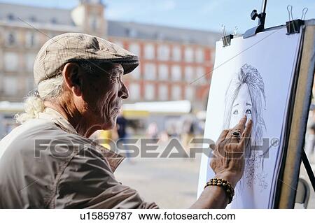 Stock Photo - Mature male street artist drawing on canvas in town square, head and shoulders, Madrid, Spain. Fotosearch