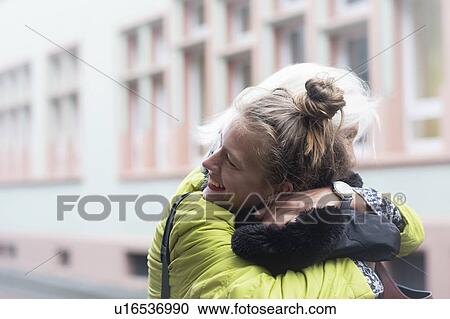 Mature woman and daughter hugging on city street View Large Photo Image Stock Image - Mature woman and daughter hugging on city street. Fotosearch