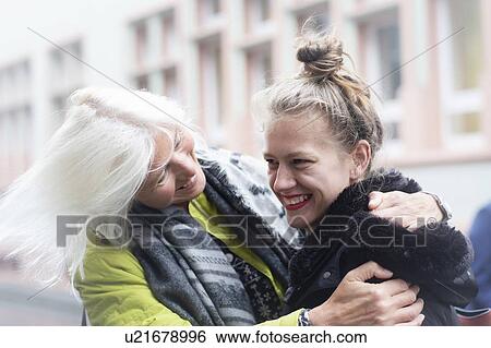 Mature woman and daughter hugging on city street View Large Photo Image Stock Photograph - Mature woman and daughter hugging on city street. Fotosearch