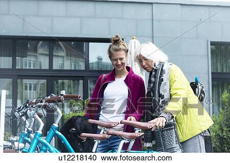 Mature woman and daughter looking at city bicycles at bike park View Large Photo Image Stock Image - Mature woman and daughter looking at city bicycles at bike park. Fotosearch