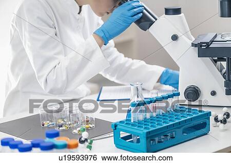 Stock Photograph - Medical researcher using microscope. Fotosearch