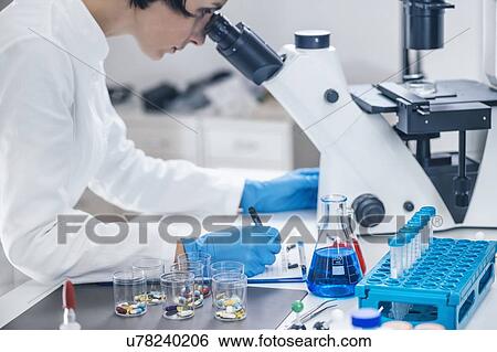 Stock Photograph - Medical researcher using microscope. Fotosearch