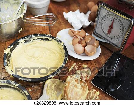 Messy baking preparation on kitchen table with cake mixture, kitchen scales, kitchen utensils and digital tablet View Large Photo Image Stock Photo - Messy baking preparation on kitchen table with cake mixture, kitchen scales, kitchen utensils and digital tablet. Fotosearch