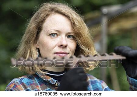 Mid adult woman holding garden rake, head and shoulder portrait View Large Photo Image Stock Photography - Mid adult woman holding garden rake, head and shoulder portrait. Fotosearch