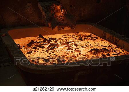 Stock Photo - Molten hot titanium metal alloy cooling in titanium recycling plant. Fotosearch