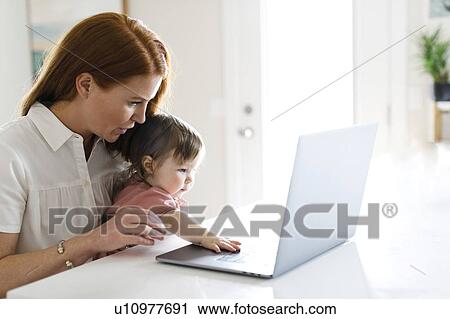 Stock Image - Mother and daughter using laptop. Fotosearch