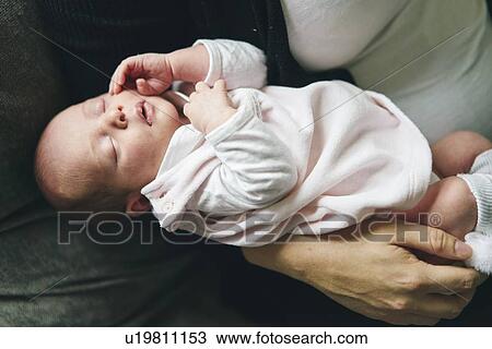 Mother cradling baby in arms View Large Photo Image Stock Image - Mother cradling baby in arms. Fotosearch