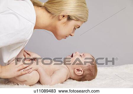 Stock Image - Mother gently calming crying baby boy. Fotosearch