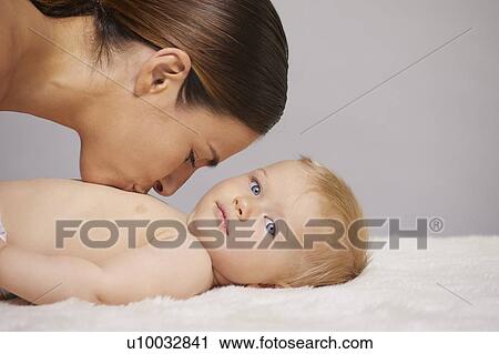 Mother kissing baby on chest View Large Photo Image Stock Image - Mother kissing baby on chest. Fotosearch