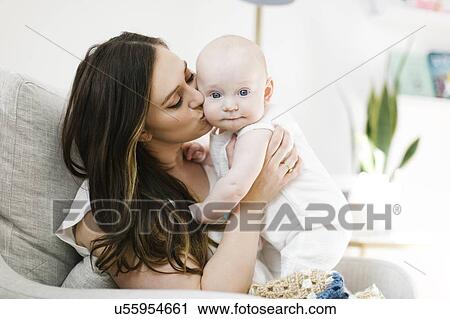Mother kissing her baby boy's cheek View Large Photo Image Stock Image - Mother kissing her baby boy's cheek. Fotosearch