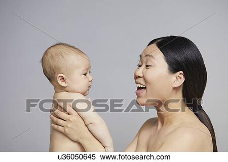 Stock Photography - Mother playing with baby boy. Fotosearch