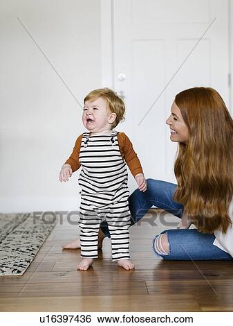 Stock Photograph - Mother smiling by her crying son. Fotosearch