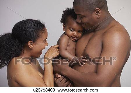 Stock Photo - Mother tickling baby boy in father's arms. Fotosearch
