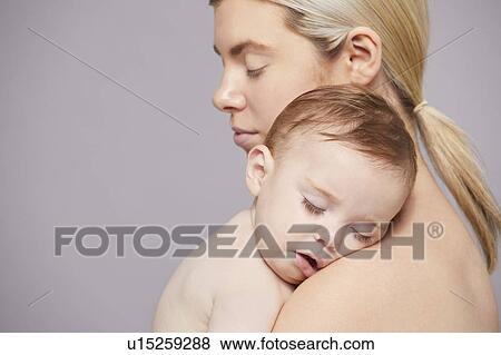 Mother with baby boy sleeping on shoulder View Large Photo Image Stock Photo - Mother with baby boy sleeping on shoulder. Fotosearch
