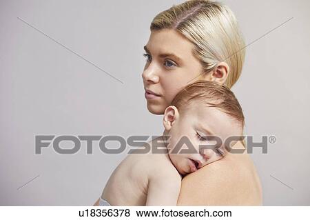 Stock Photo - Mother with baby boy sleeping on shoulder. Fotosearch