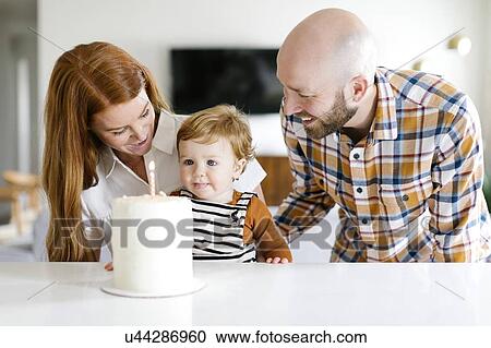 Stock Image - Parents and son with birthday cake. Fotosearch