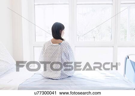 Patient sitting on hospital bed, rear view View Large Photo Image Stock Image - Patient sitting on hospital bed, rear view. Fotosearch