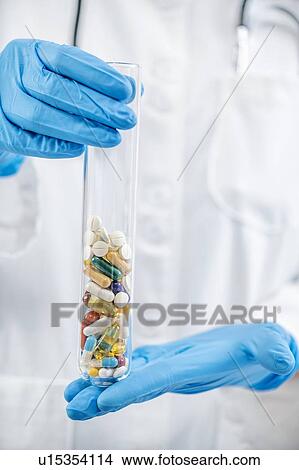 Picture - Pharmaceuticals glass test tube filled with colourful pills. Fotosearch