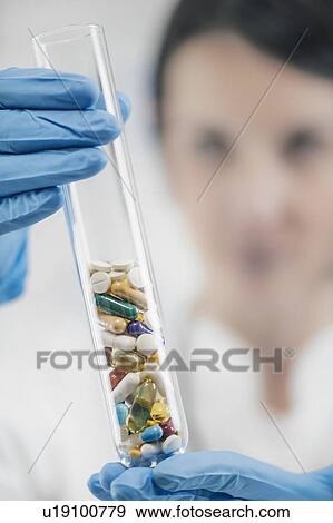 Stock Photo - Pharmaceuticals glass test tube filled with colourful pills. Fotosearch