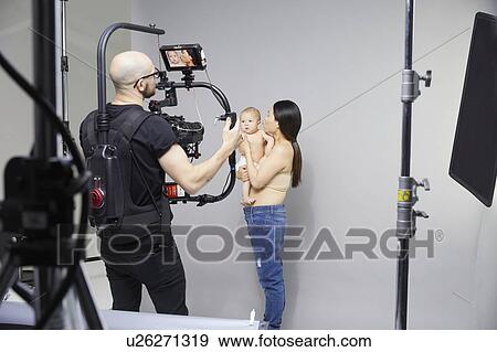 Stock Photo - Photographer taking portrait of mother and baby. Fotosearch
