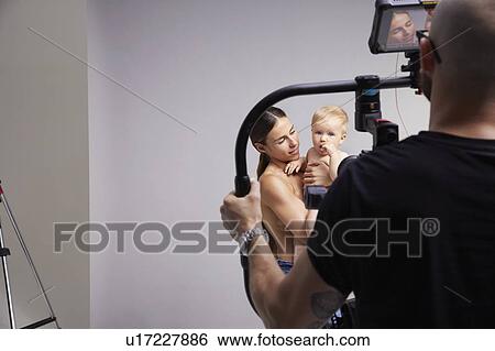 Photographer taking portrait of mother and baby View Large Photo Image Stock Photograph - Photographer taking portrait of mother and baby. Fotosearch