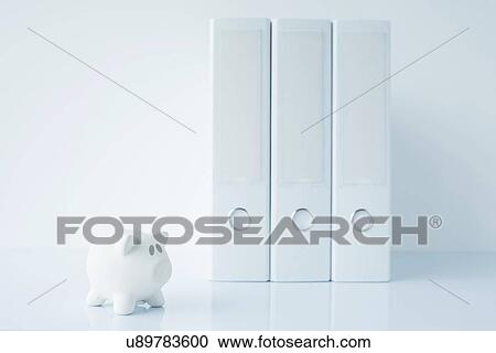 Stock Image - Piggy bank and ring binders. Fotosearch