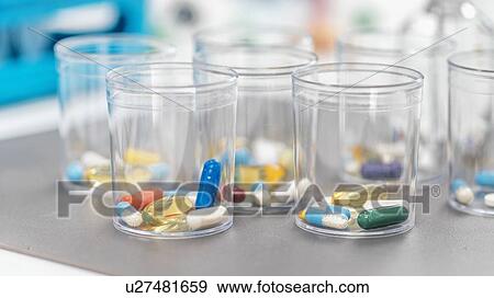 Stock Photo - Pills in a disposable plastic cup. Fotosearch