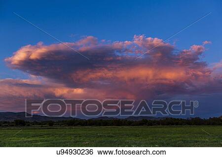 Stock Photograph - Pink clouds over field in Picabo, Idaho, USA. Fotosearch