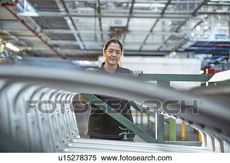 Portrait of female apprentice with car parts in car factory View Large Photo Image Stock Photography - Portrait of female apprentice with car parts in car factory. Fotosearch