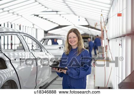 Portrait of female worker with digital tablet in paint inspection area of car factory View Large Photo Image Stock Photo - Portrait of female worker with digital tablet in paint inspection area of car factory. Fotosearch