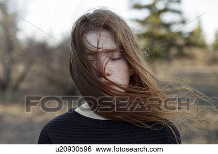 Stock Photograph - Portrait of windswept teenage girl with her eyes closed. Fotosearch