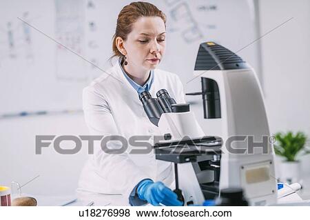Stock Photo - Portrait of young female archaeologist with microscope. Fotosearch