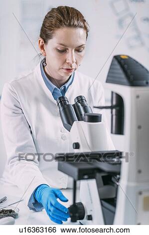 Stock Photograph - Portrait of young female archaeologist with microscope. Fotosearch