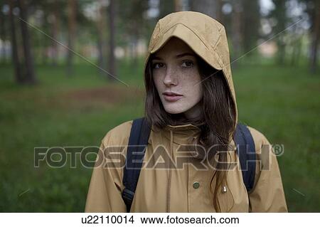 Portrait of young woman wearing brown raincoat View Large Photo Image Picture - Portrait of young woman wearing brown raincoat. Fotosearch
