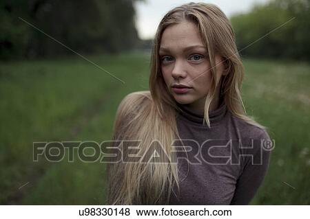 Portrait of young woman with blond hair in field View Large Photo Image Stock Photo - Portrait of young woman with blond hair in field. Fotosearch