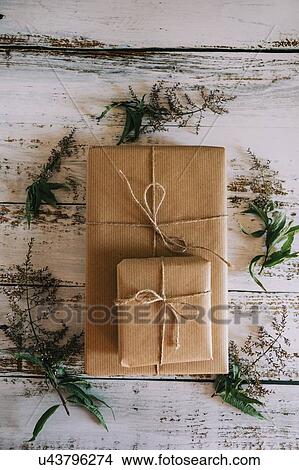 Presents wrapped in brown paper and string with flowers View Large Photo Image Picture - Presents wrapped in brown paper and string with flowers. Fotosearch