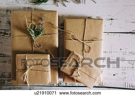 Presents wrapped in brown paper and string with flowers View Large Photo Image Stock Image - Presents wrapped in brown paper and string with flowers. Fotosearch
