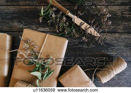 Presents wrapped in brown paper and string with flowers and knife View Large Photo Image Stock Photo - Presents wrapped in brown paper and string with flowers and knife. Fotosearch