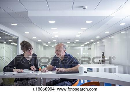 Picture - Print worker discussing print job with client in print factory. Fotosearch